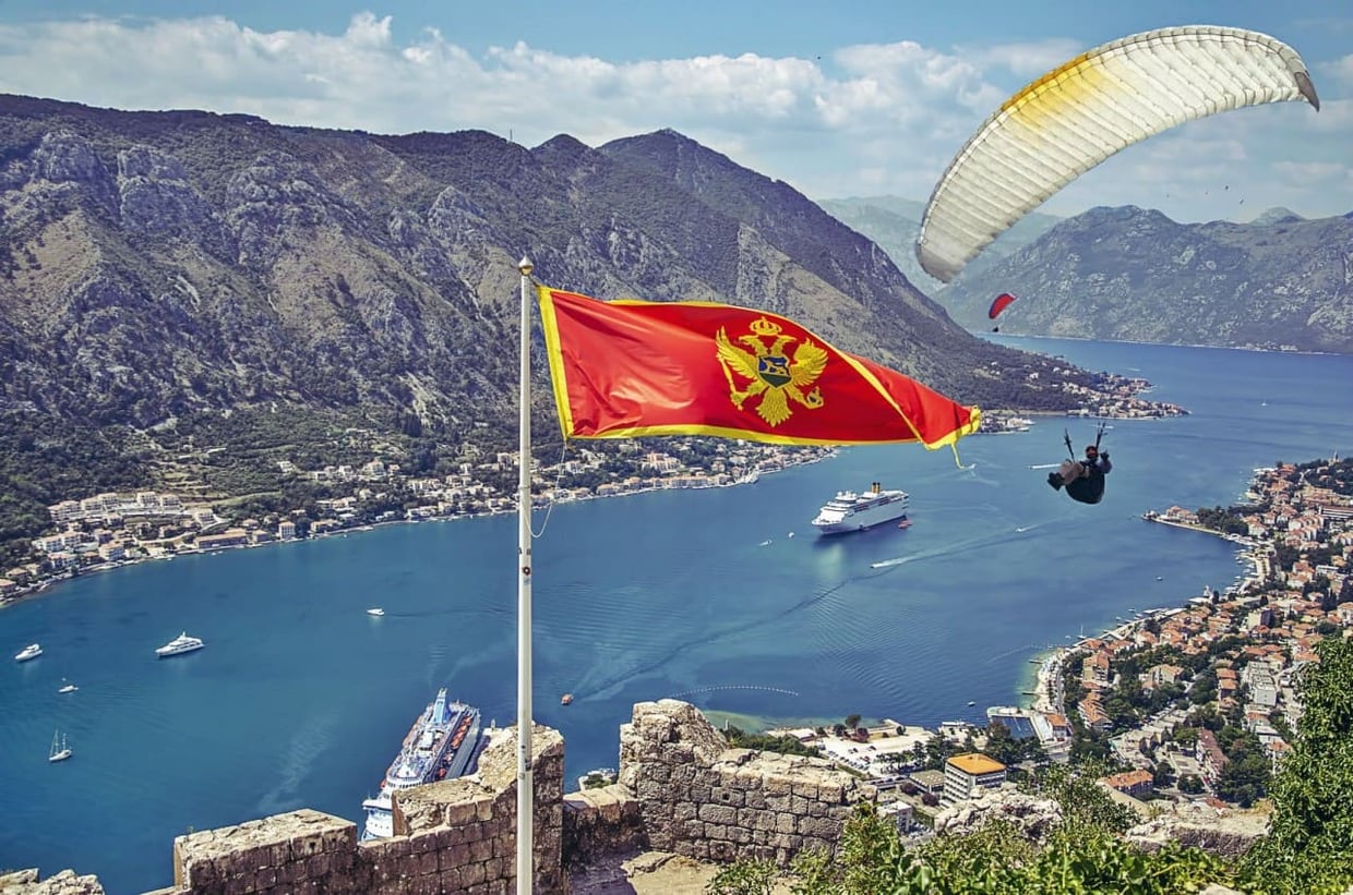 Montenegro flag above a coastal landscape, anchoring the national guide context